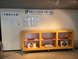 発掘調査で出土した土器・石器などの遺物や写真パネルを展示している様子