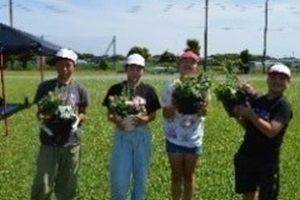 寄せ植えの鉢を手に持った児童4人の写真