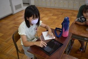 タブレットを使って新聞記者体験をしている写真