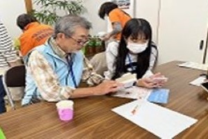 生徒が高齢者を手伝っている写真